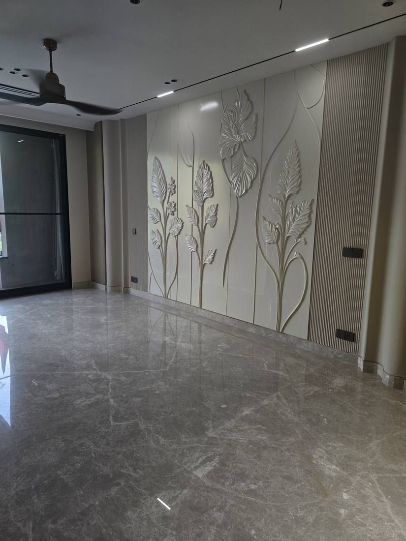 Living room wall with a 3D botanical relief in champagne above a marble floor