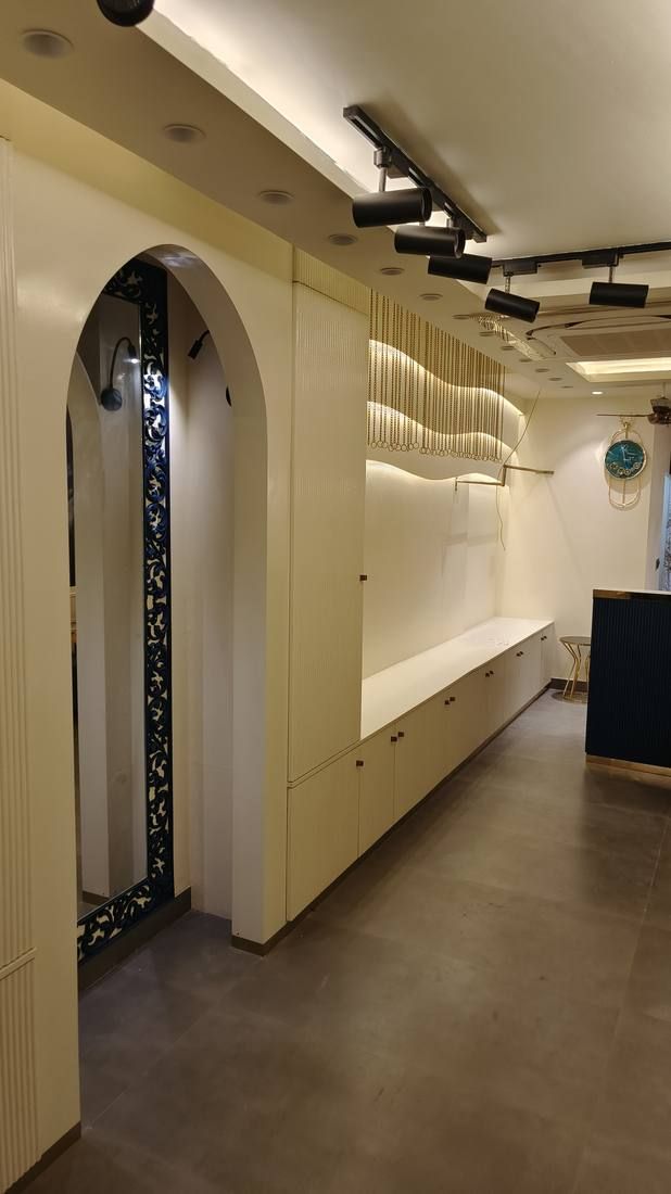 Arched doorway and lit display shelving in cream