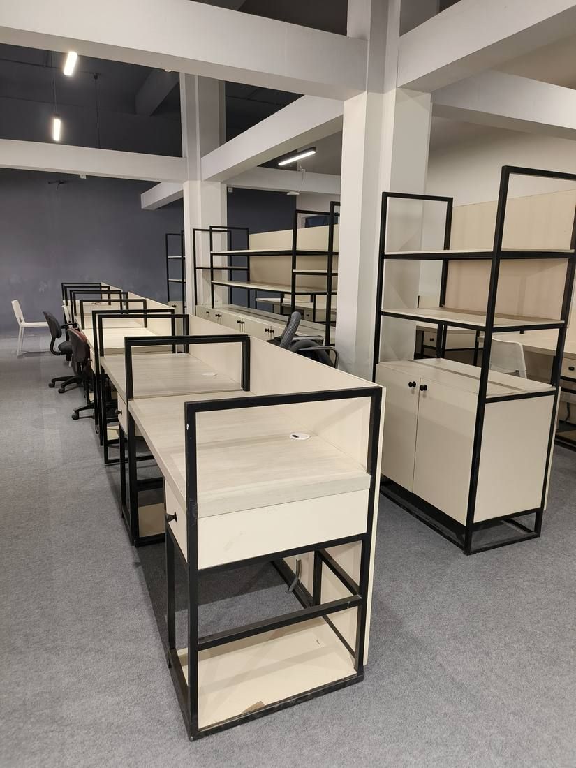 Workstations divided by black steel-framed shelving units