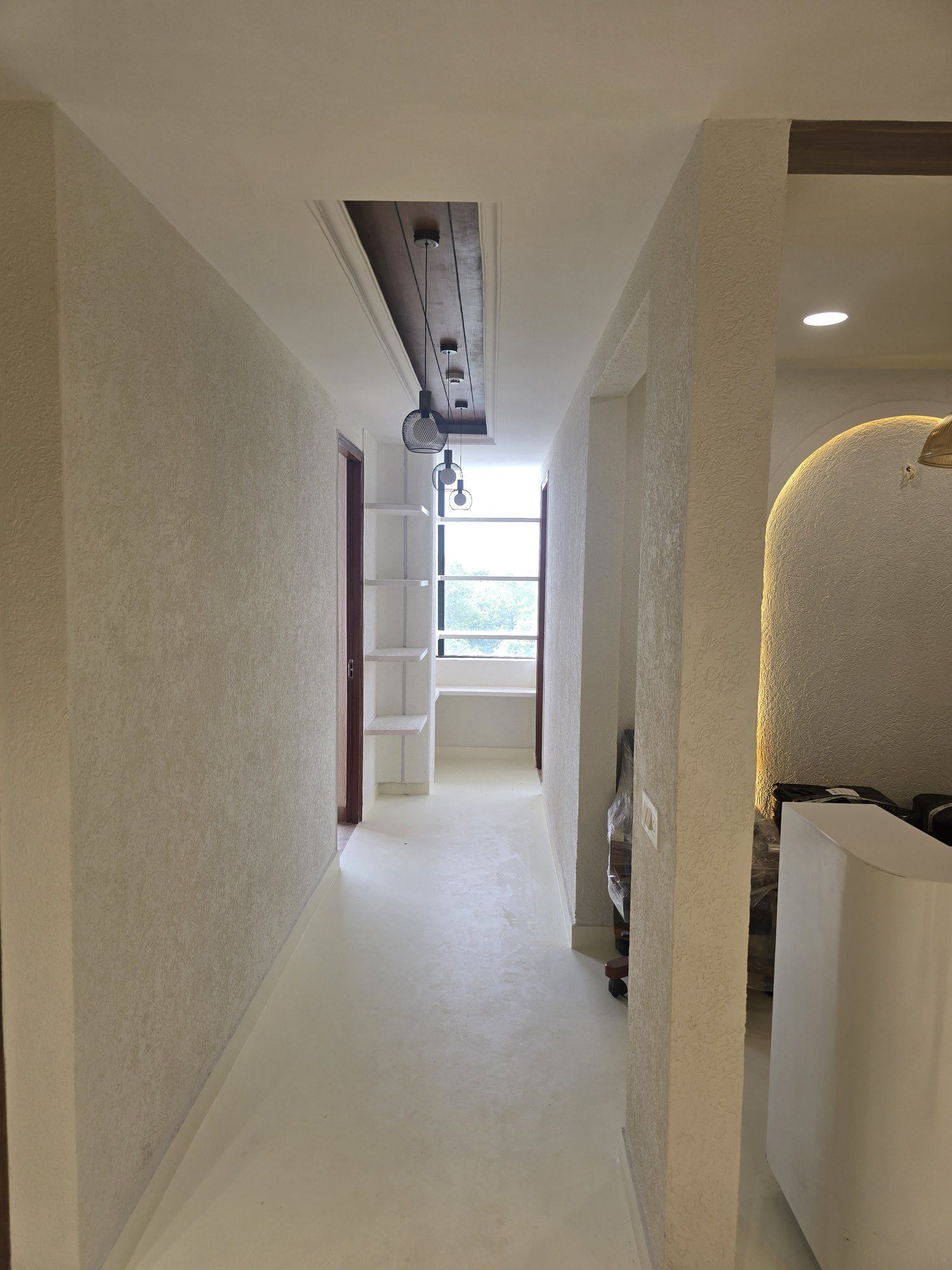 Corridor with textured stone-finish walls, a timber ceiling strip and a lit arched niche