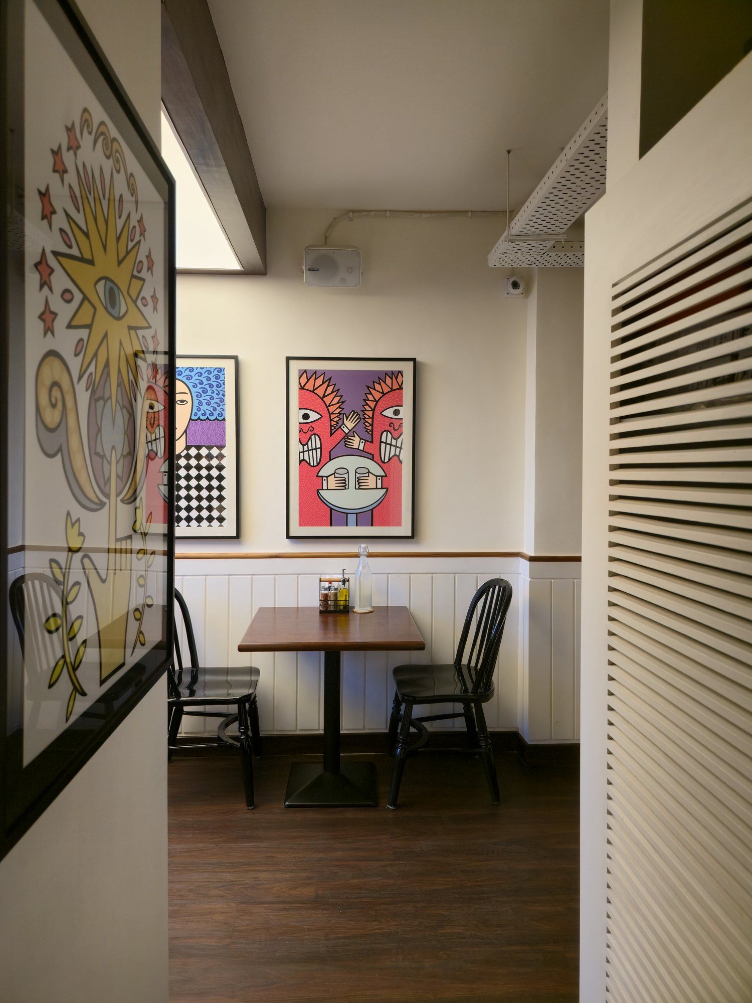 Passage lined with pop-art leading to a table for two