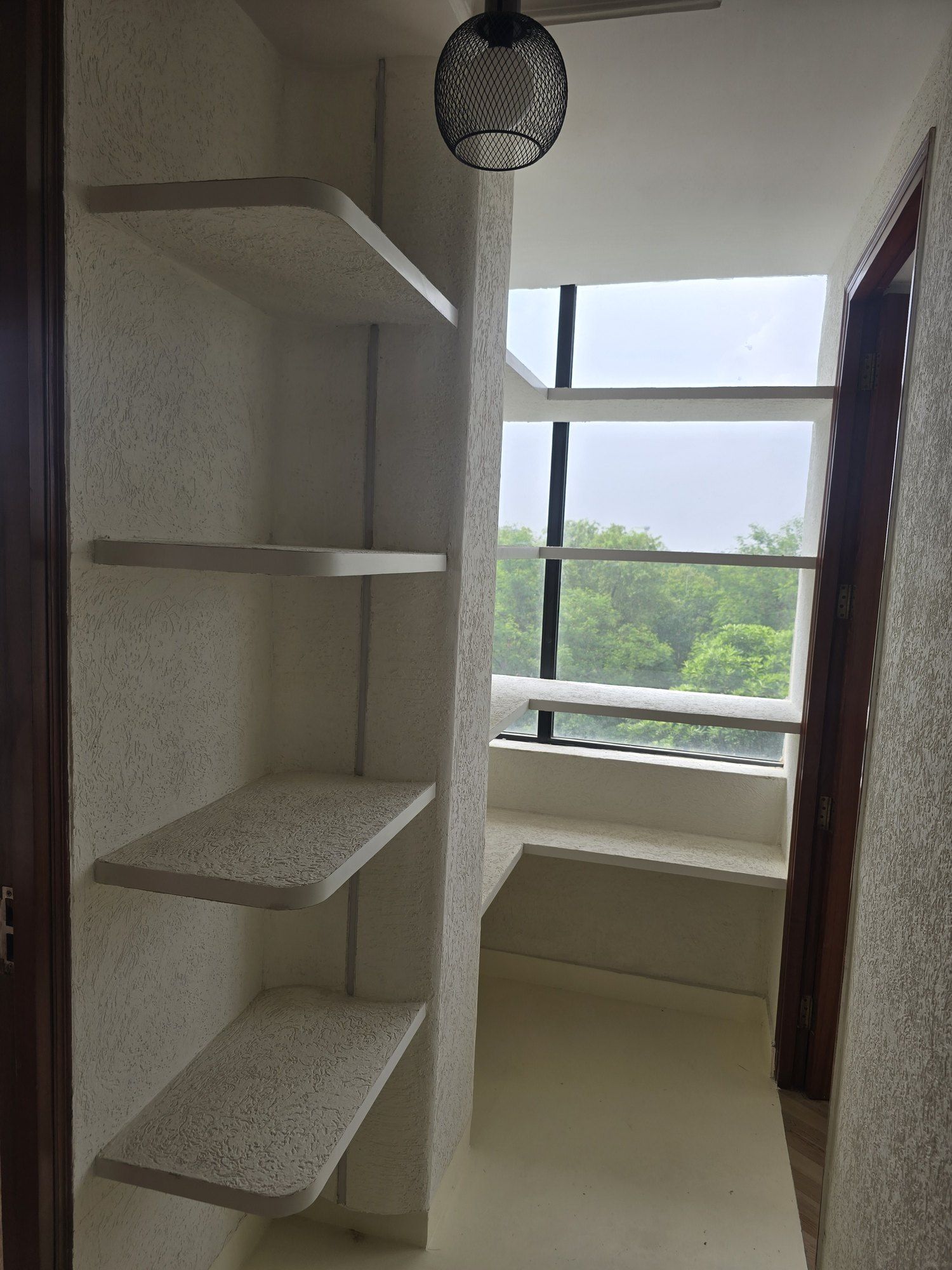 Floating shelves in a textured niche beside a window